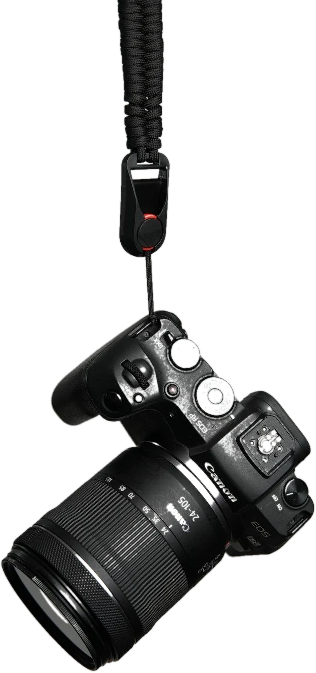 A Canon EOS RP with a 24 to 105 lens, hanging by its strap